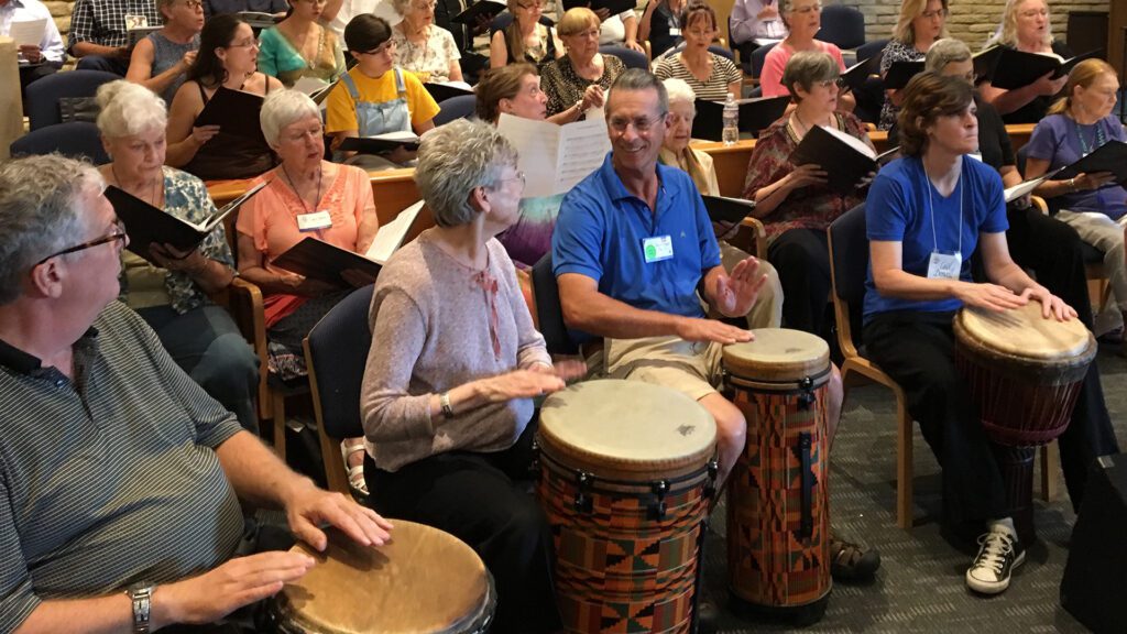 4 hand drummers seated in front of UUCP choir members, also seated