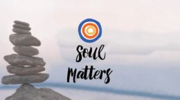 Concentric circles above "Soul Matters" in black script over a background of a cairn of stones with misty water in the background
