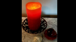 A lighted candle sitting on a marble table top