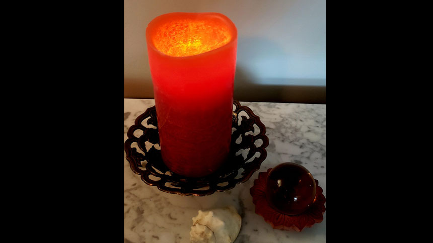 A lighted candle sitting on a marble table top