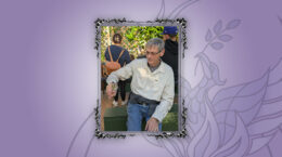 UUCP Member Gary Ezzell sitting outdoors with a butterfly perched on his finger